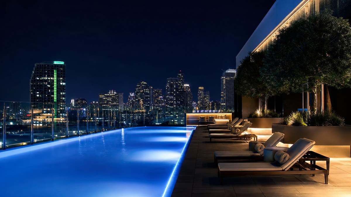 Rooftop apartment pool in a Texas city at night with blue fiber optic edge lighting and skyline view